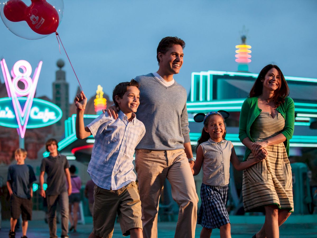 A family joyfully walks at an amusement park, holding hands and a balloon, with neon lights and a retro diner in the background.